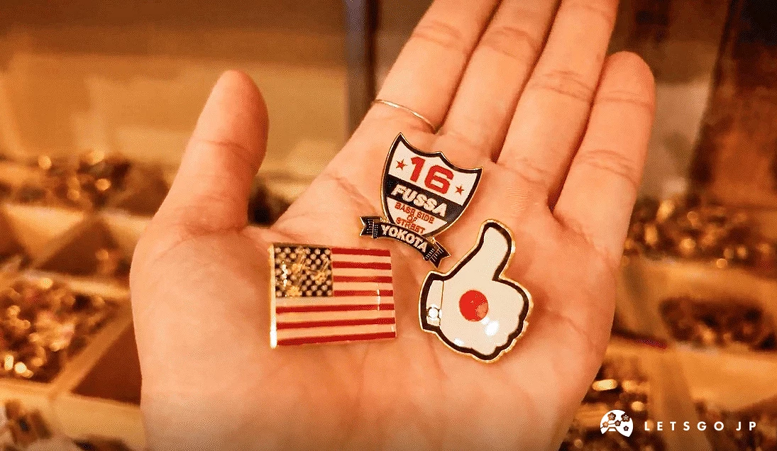 手掌上放著日本與美國國旗的徽章